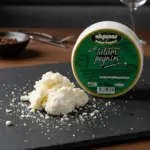 Yakın planda iri parçalı tulum peyniri ve arkada Akpınar Erzincan Tulum Peyniri 450 gr kabı.