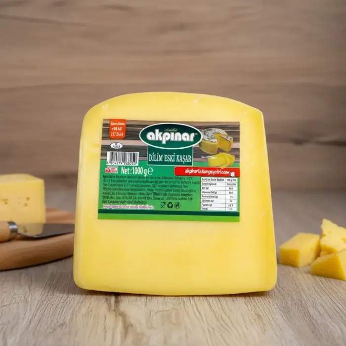 Akpınar Dilim Eski Kaşar Peyniri 1000 gr, ahşap zemin üzerinde sade bir sunumla fotoğraflanmıştır.