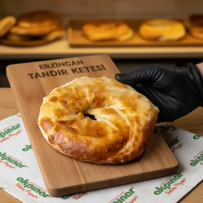 Ahşap sunum tahtasında eldivenle tutulan Erzincan tandır ketesi
